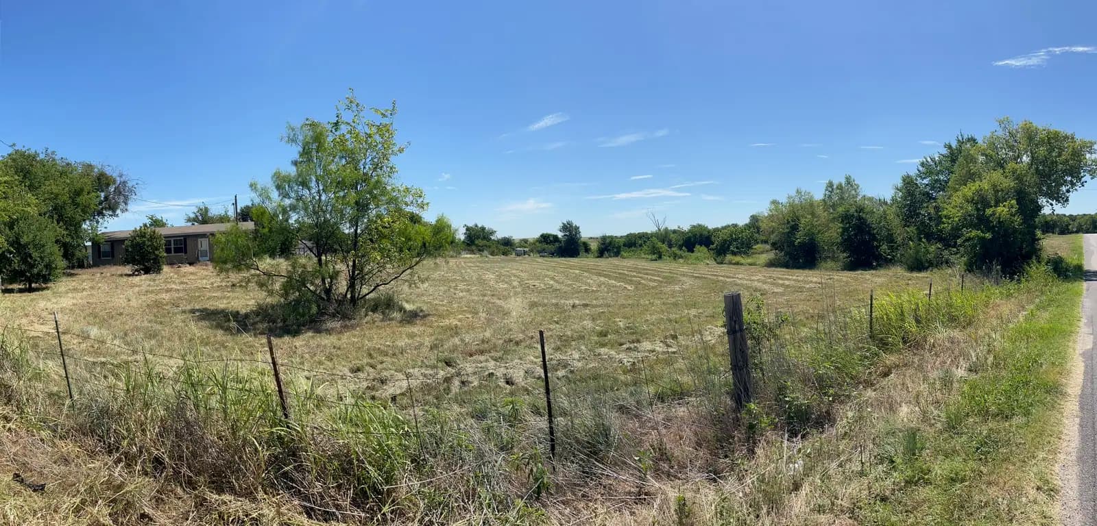 Summer pasture and fence line ready for brush hog mowing in Granbury, TX